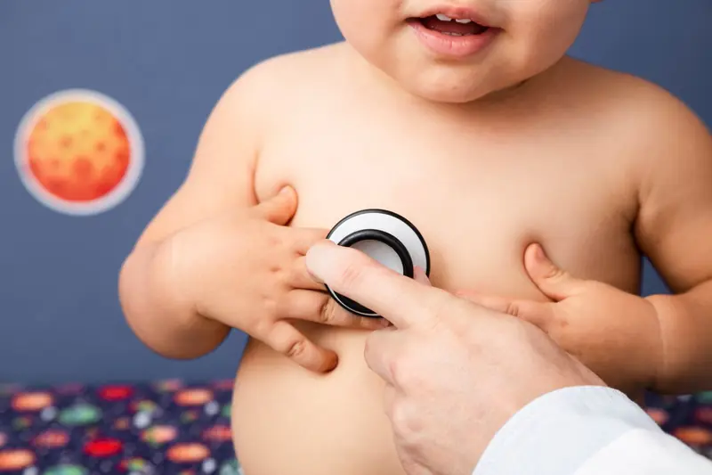 Médico auscultando el pecho de un bebé con estetoscopio